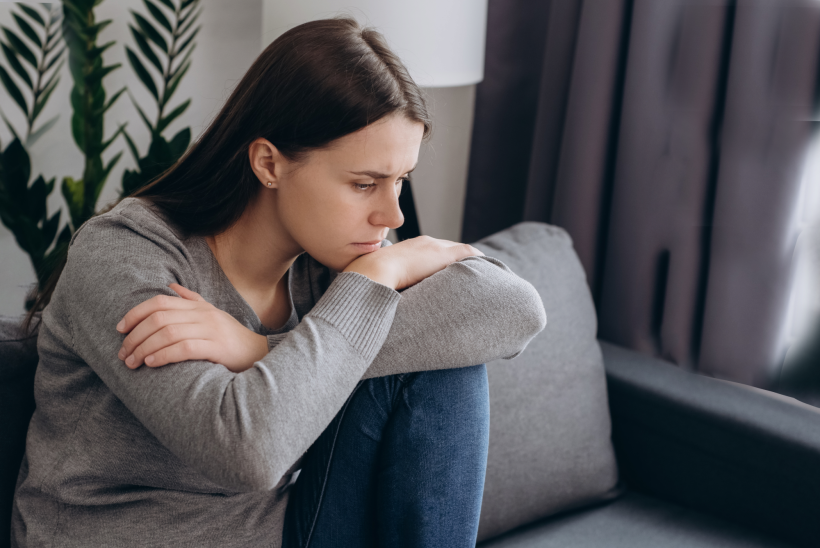 Femme anxiété assise sur le canapé CBD